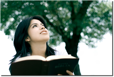 woman looking into the distance while holding a Bible