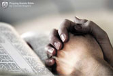 prière – mains jointe en prière sur une bible ouverte